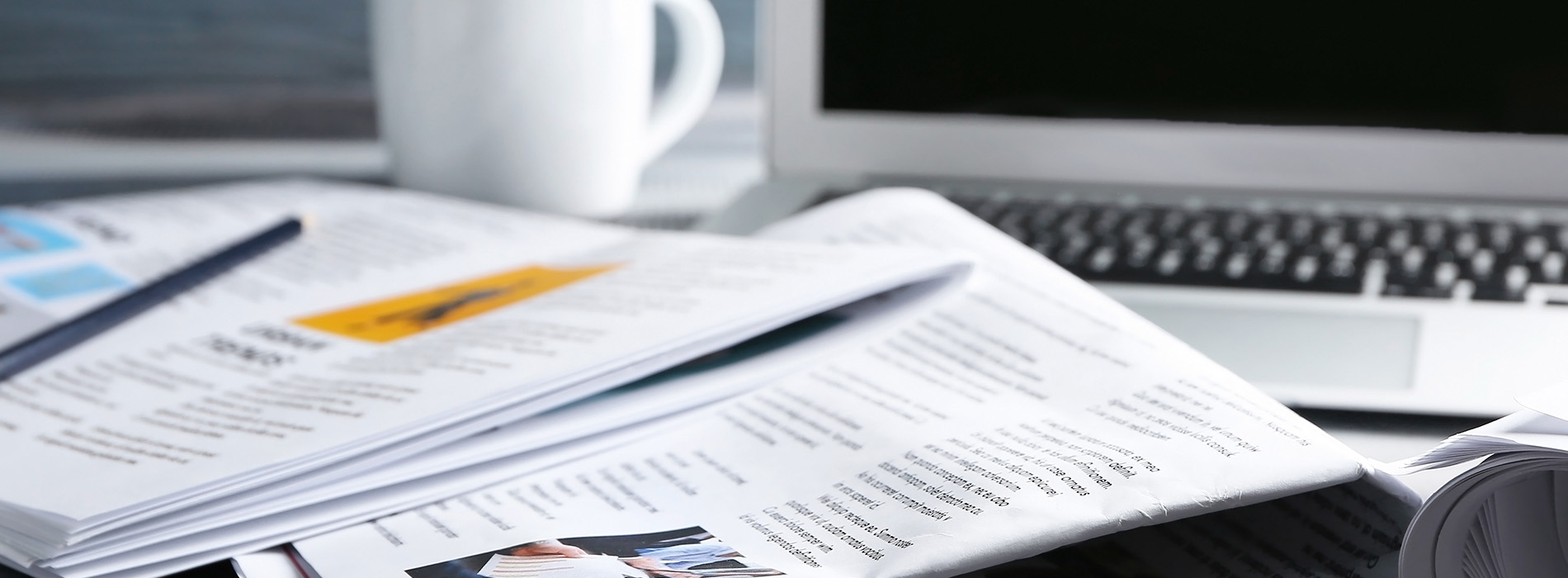 The image shows a workspace with various papers and documents spread across a desk, accompanied by a computer keyboard and mouse.