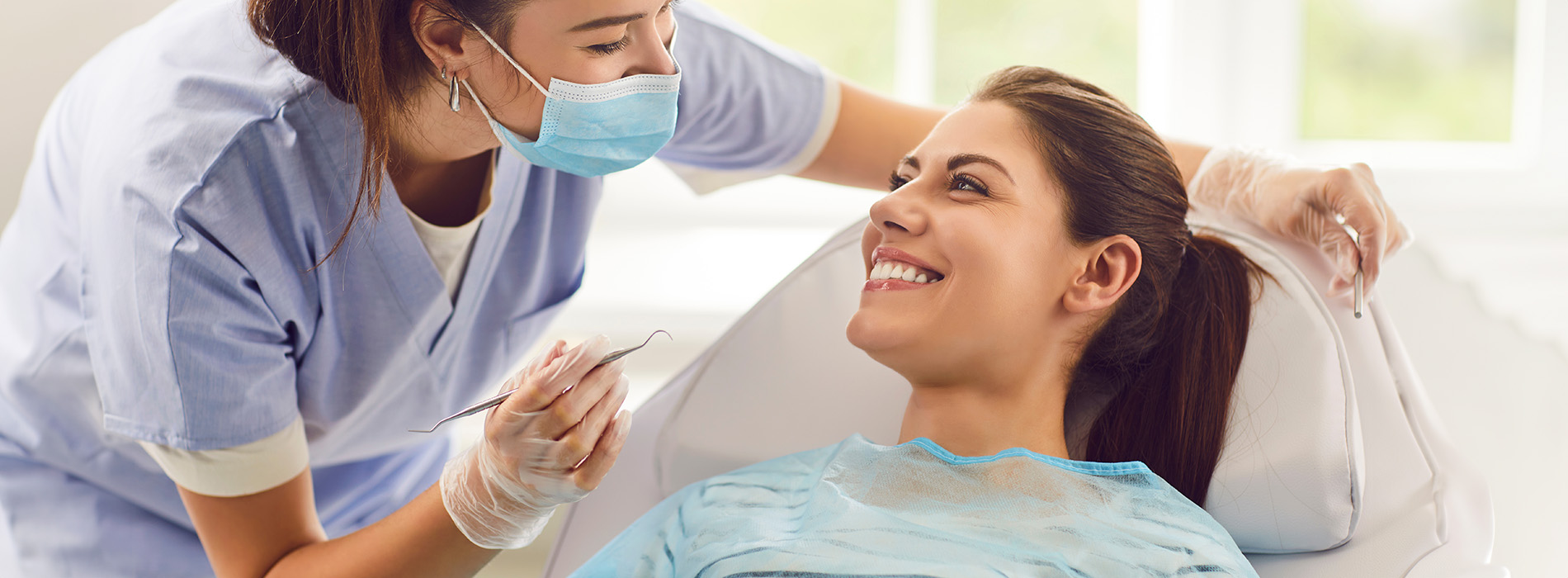 A well-lit reception area with a desk, computer monitor, and potted plant.