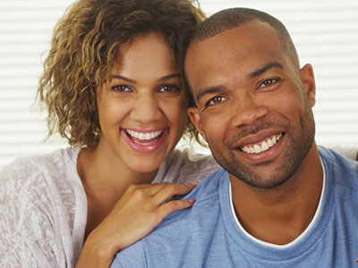 The image shows a man and a woman posing together with smiles  they appear to be a couple enjoying a moment of happiness.